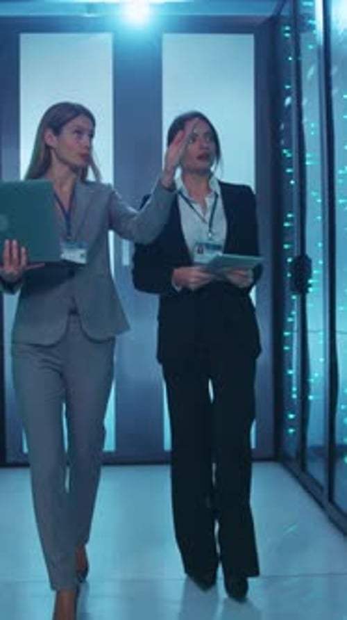 Two Dedicated Businesswomen are Seen Walking Through a Contemporary Corporate Office Environment