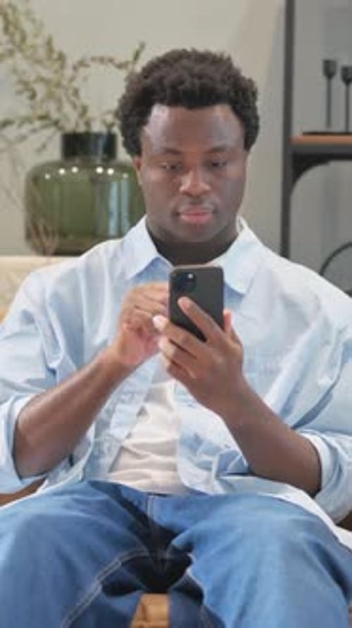 Young Adult Uses Mobile Phone Indoors