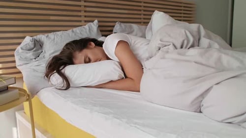 Woman Sleeping Peacefully in Bed in the Morning