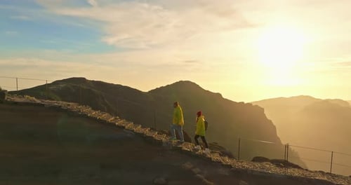 Couple Hiking on Mountain Path at Sunrise