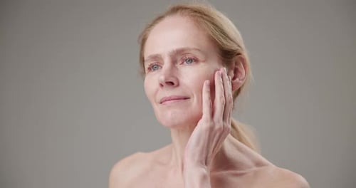 Woman Touches Face Gently in Close-Up Portrait