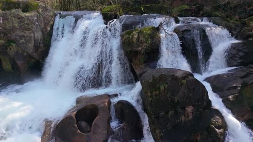 Gushing Cascades Through Granite Rocks Of Fervenza Da Noveira Waterfall In The Province Of A Coruna,