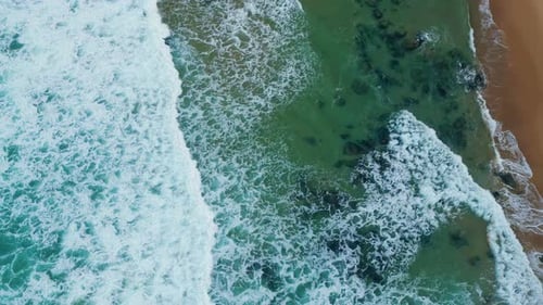 Luftaufnahme türkisfarbener Wellen, die am tropischen Sandstrand in Super Slow rollen