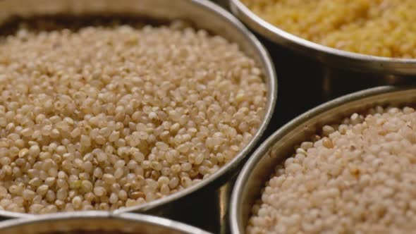 Different types of millets in stored in steel bowls, 4k, close up, push ...