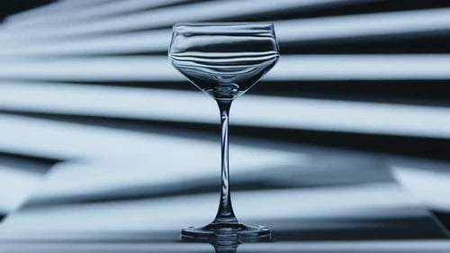 Un verre à vin transparent clignote momentanément par des motifs lumineux striés