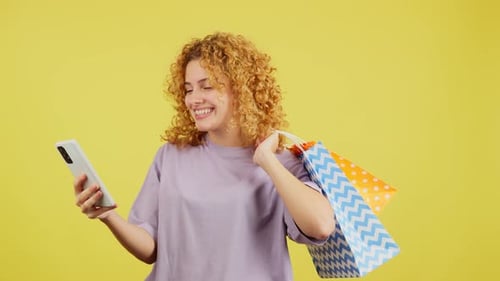 Femme prenant un selfie en tenant des sacs à provisions
