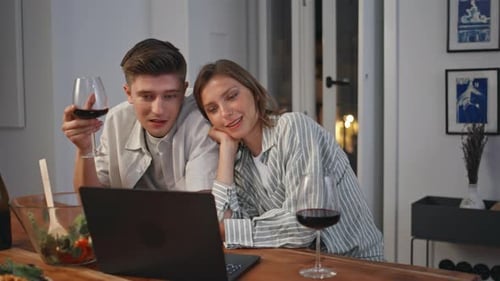 Couple Relaxing at Home with Wine and Laptop