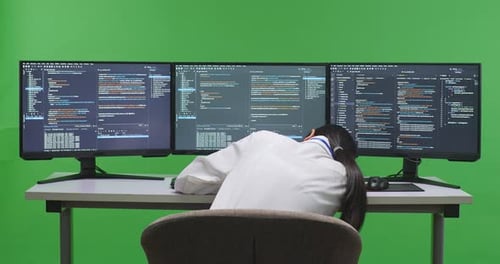 Tired Asian Woman Developer Sleeping While Write Code With Multiple Computer Screens In Green Screen