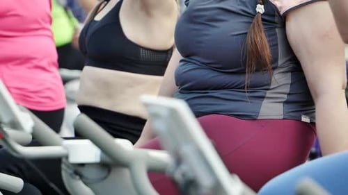 Las mujeres gordas queman grasa en una bicicleta de ejercicio al aire libre