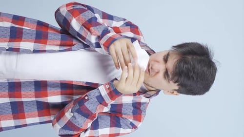 Young Adult Man Sneezing and Using a Tissue