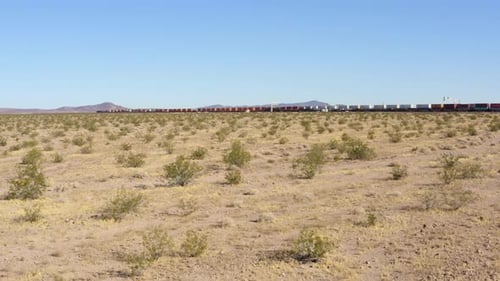 Niedriger Blick auf zwei extrem lange Güterzüge, die auf geraden Bahngleisen im Schreibtisch aneinander vorbeifahren
