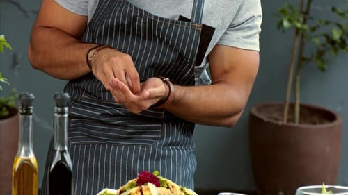 Chef Adds Garnish to Fresh Salad Preparation