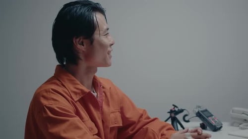 Sneaky Asian Criminal Speaking with Detective during Interrogation