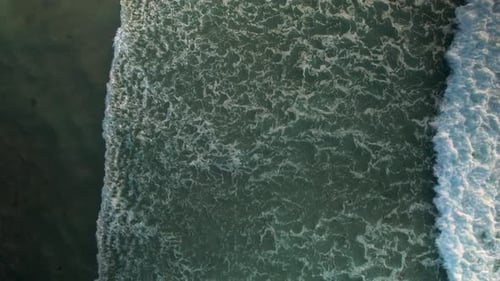 Ocean Splashing On The Shoreline With Foamy Waves