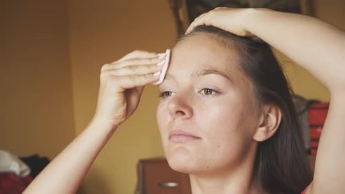 Woman Cleaning Face with Cotton