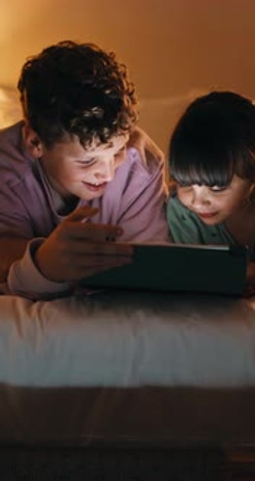 Night, siblings and laugh in bedroom with tablet for online streaming, humor or cartoons together