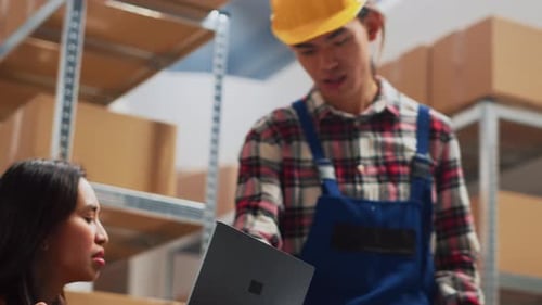 Warehouse Workers Discussing Inventory with Laptop