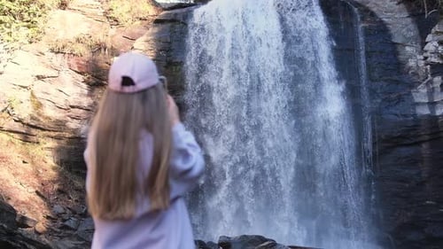 A Girl and a Woman Capture a Beautiful Waterfall Creating Memories