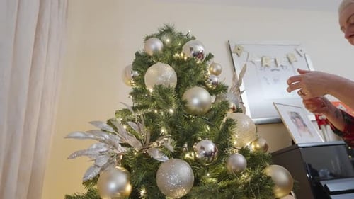 Woman Decorating Christmas Tree at Home