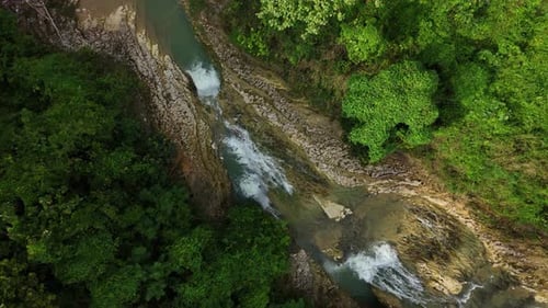 Aerial footage from top of small river in the forest