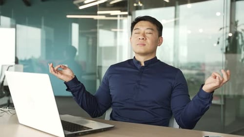 Man Meditating at Office Desk for Relaxation