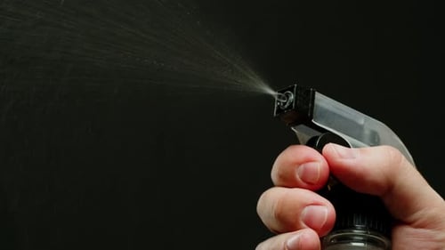 Young Man Applying Perfume to Skin in the Dark Close Up of Spraying Deodorant Luxury Perfume