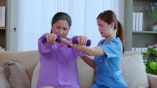 Senior Woman Exercises with Dumbbells at Home