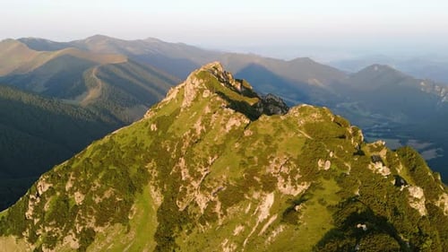 Aerial Drone Orbit Shot Around a Majestic Mountain Peak at Sunset