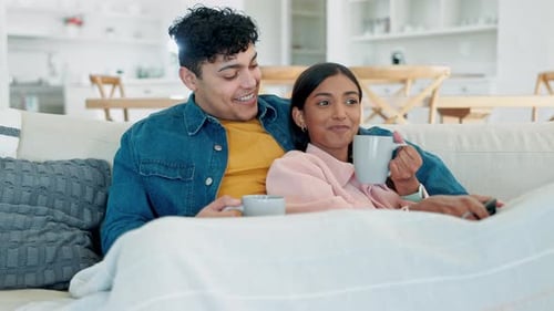 Happy Couple Relaxing on Sofa with Coffee
