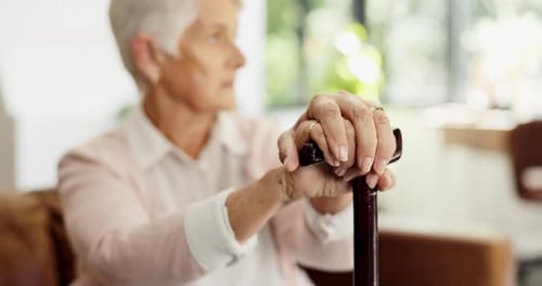 Senior woman, hands and walking stick on sofa with assisted living or nursing home experience