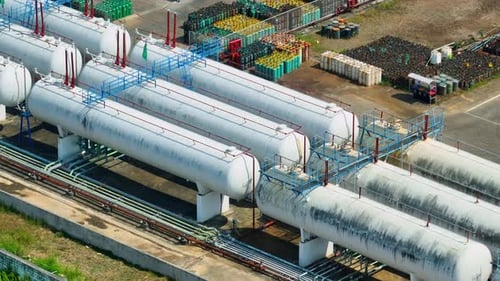 Aerial view of a gas factory with large horizontal storage tanks.