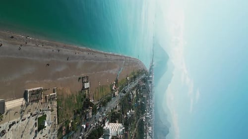 Vertical Shot of a Flying Camera Over a City Beach on the Mediterranean Sea