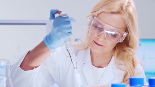 Woman Scientist Using Pipette in Modern Laboratory