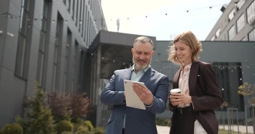 Business People Looking at Tablet Outside Building