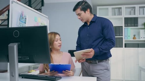 Caucasian businessman and Asian businesswoman people working in office.