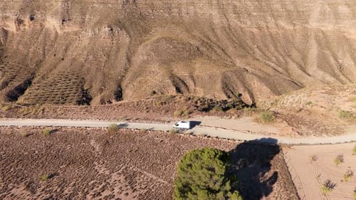 White Camper Van Driving on a Desolate Road in the Gorafe Desert