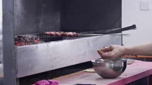 Mestre turco de kebab coloca carne no espeto e cozinha no churrasco