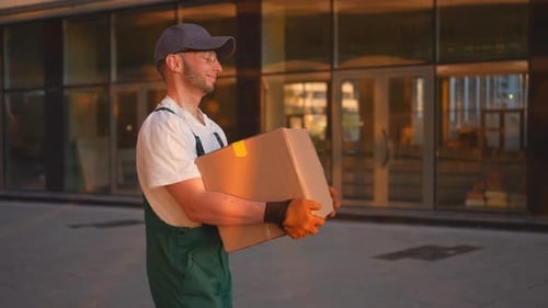 Young Adult Man Carrying Box in Urban Setting