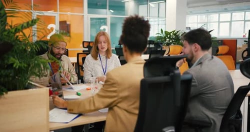 Diverse Professionals Collaborate Sitting at Table in Office