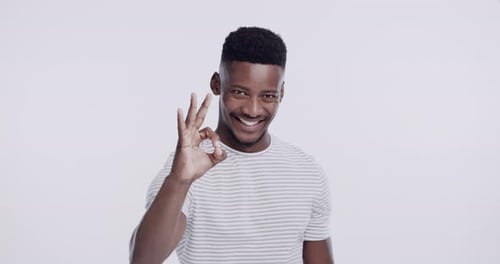 Happy, ok sign and face of black man in studio isolated on white background