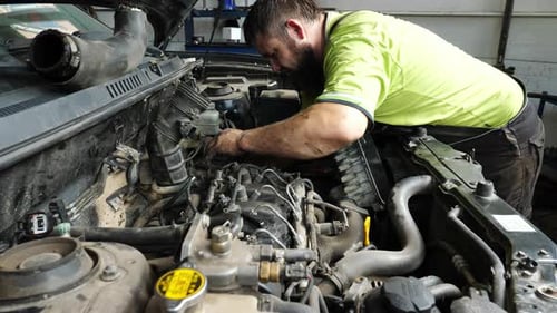 Male Repairer Making Maintenance of Car at Garage Adult Auto Mechanic Working Under Hood of Vehicle