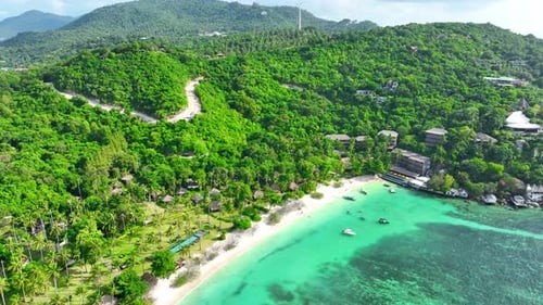 Sandy beach shore with beautiful resort surrounded by clear sea water.