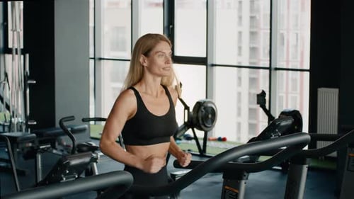 Woman Exercising on Treadmill in Modern Gym