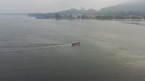 Drone fly around and flyover a traditional fishing boat sailing on the sea out for a morning catch a