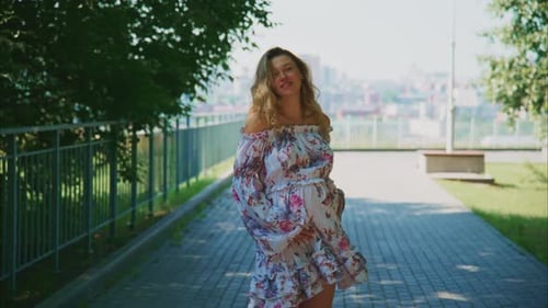 Expecting Joy in a Scenic Park During a Sunny Day a Mother Embraces Her Pregnancy Gracefully