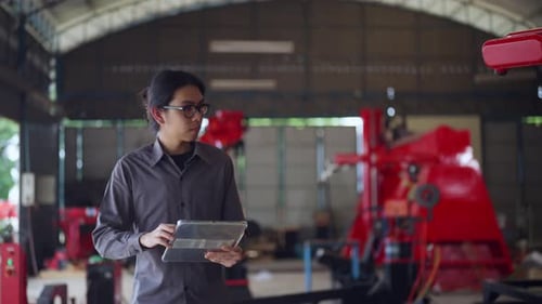 Engineer focused on a tablet while working in an robot industrial