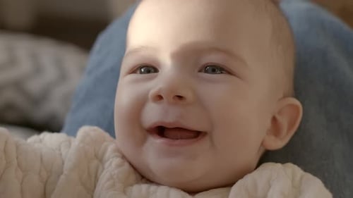 Smiling Baby Lying Down Inside in the Daylight