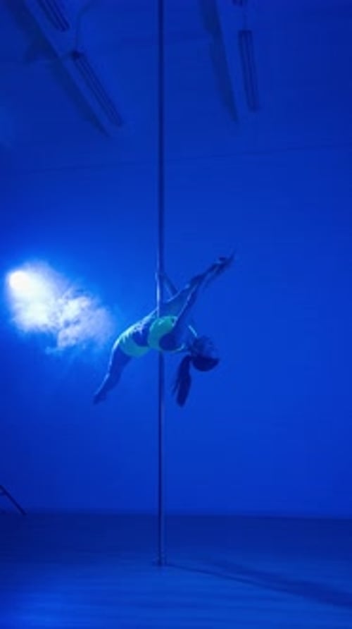 Female Pole Dancer Performing in Blue Light