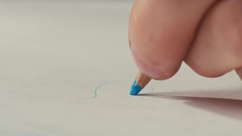 Hand Drawing with a Blue Colored Pencil