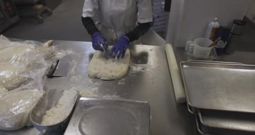 Baker with Rolling Pin Preparing Bread Dough in Bakery Kitchen 10 Seconds or Greater